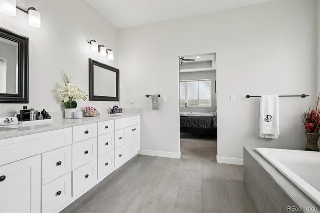 a bathroom with a double vanity sink a mirror and a bathtub