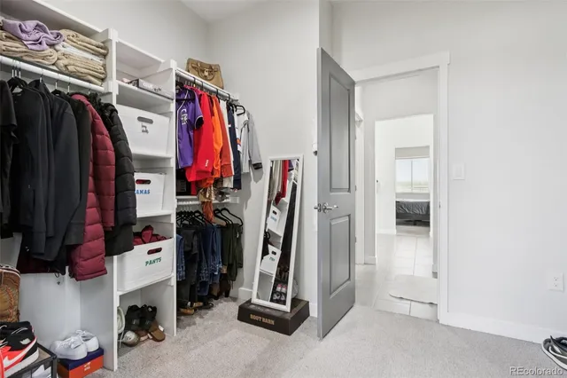 a view of walk in closet with clothes and shoes