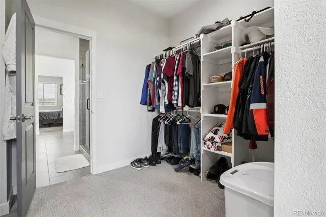 a view of walk in closet with clothes and shoes