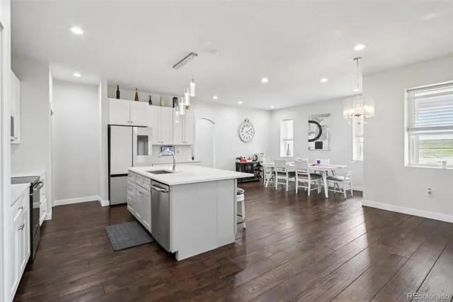 a kitchen with a sink and chairs