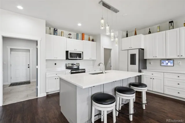 a kitchen with white cabinets and stainless steel appliances