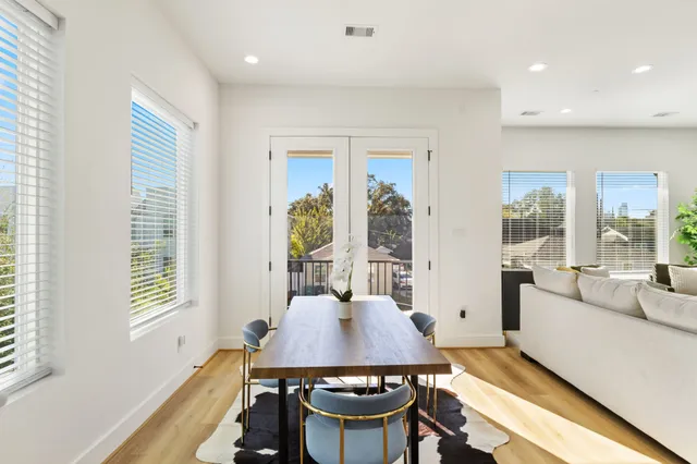a view of a a dining room with furniture window and wooden floor