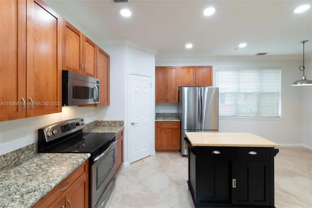a kitchen with granite countertop a refrigerator stove and sink