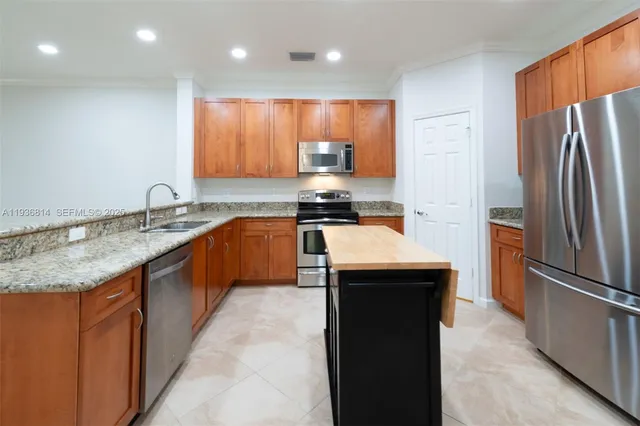 a kitchen with stainless steel appliances granite countertop a sink stove and refrigerator