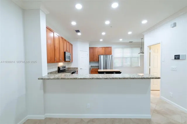 a large kitchen with granite countertop a sink and a refrigerator