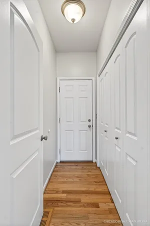 a view of a hallway with wooden floor and closet