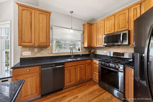 a kitchen with stainless steel appliances granite countertop wooden cabinets stove top oven and sink