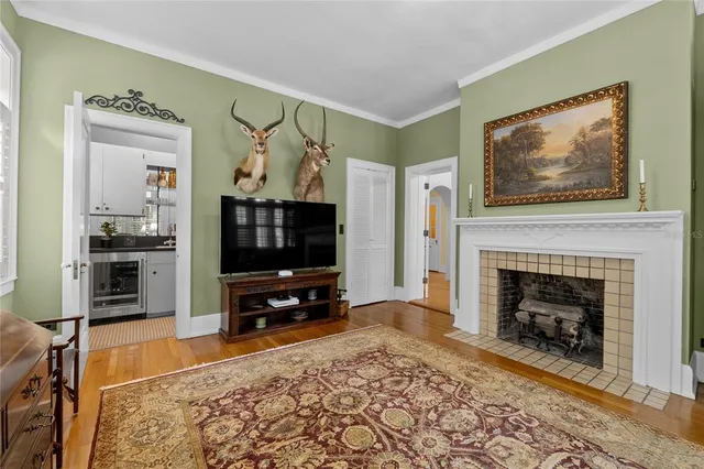 a dining room with wooden floor a chandelier a wooden table and chairs