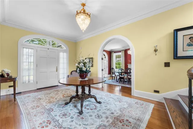 a living room with furniture a fireplace and a dining table with wooden floor