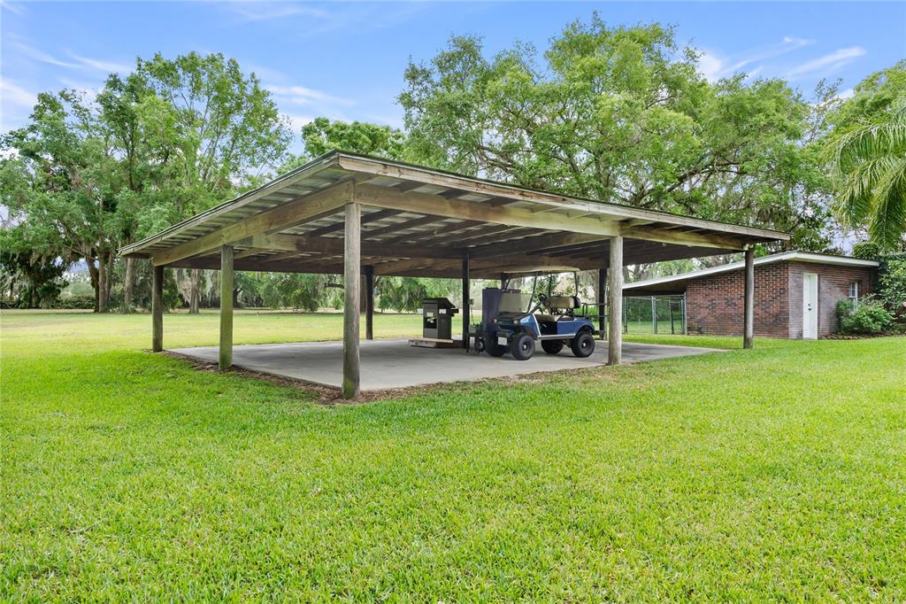 1760 Old Bartow Eagle Lake Road Bartow, FL 33830 - Photo 70 of 85 a view of a patio with table and chairs under an umbrella