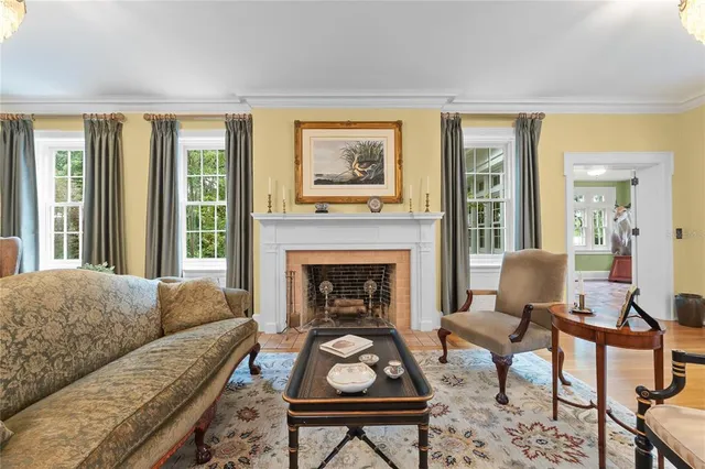 a large living room with stainless steel appliances granite countertop furniture a fireplace and a large window