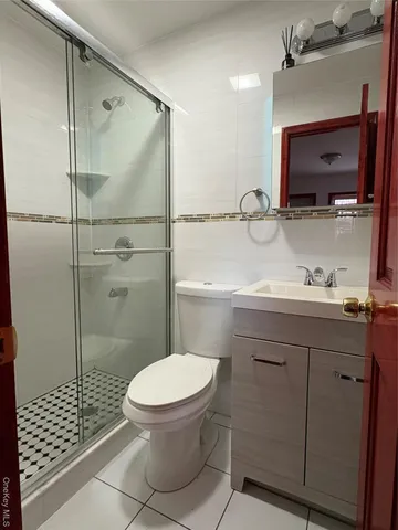a bathroom with a granite countertop toilet sink shower and mirror