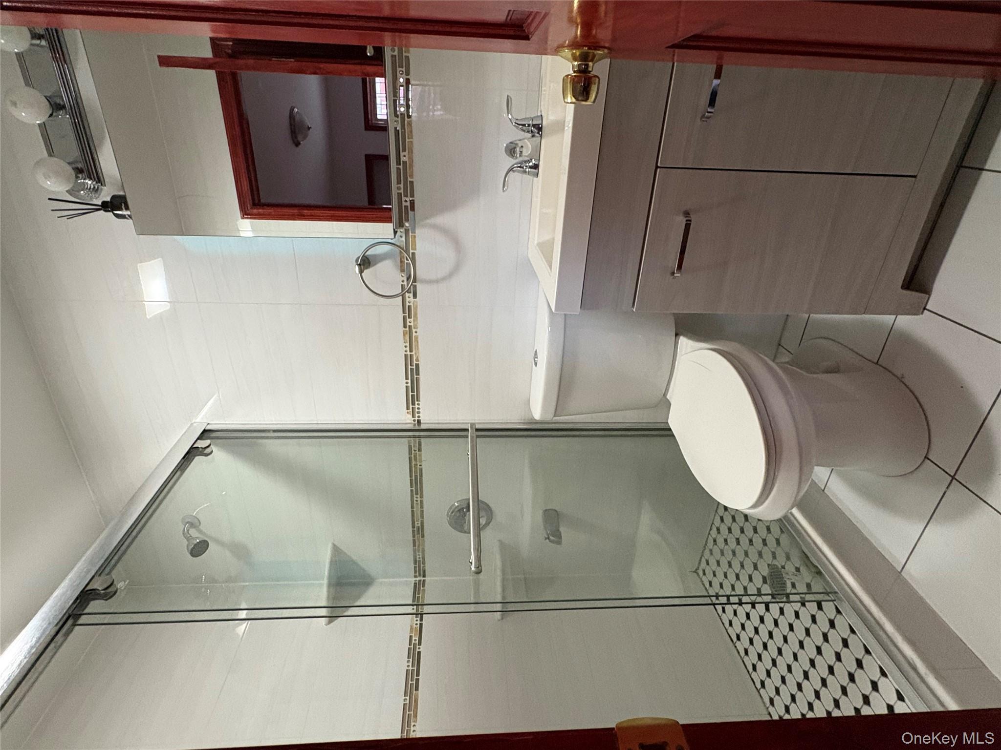 61-40 148th Street, Unit 2 Queens, NY 11367 - Photo 7 of 9 a bathroom with a granite countertop toilet sink shower and mirror