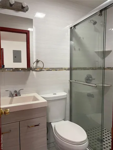 a bathroom with a sink a mirror a toilet and shower