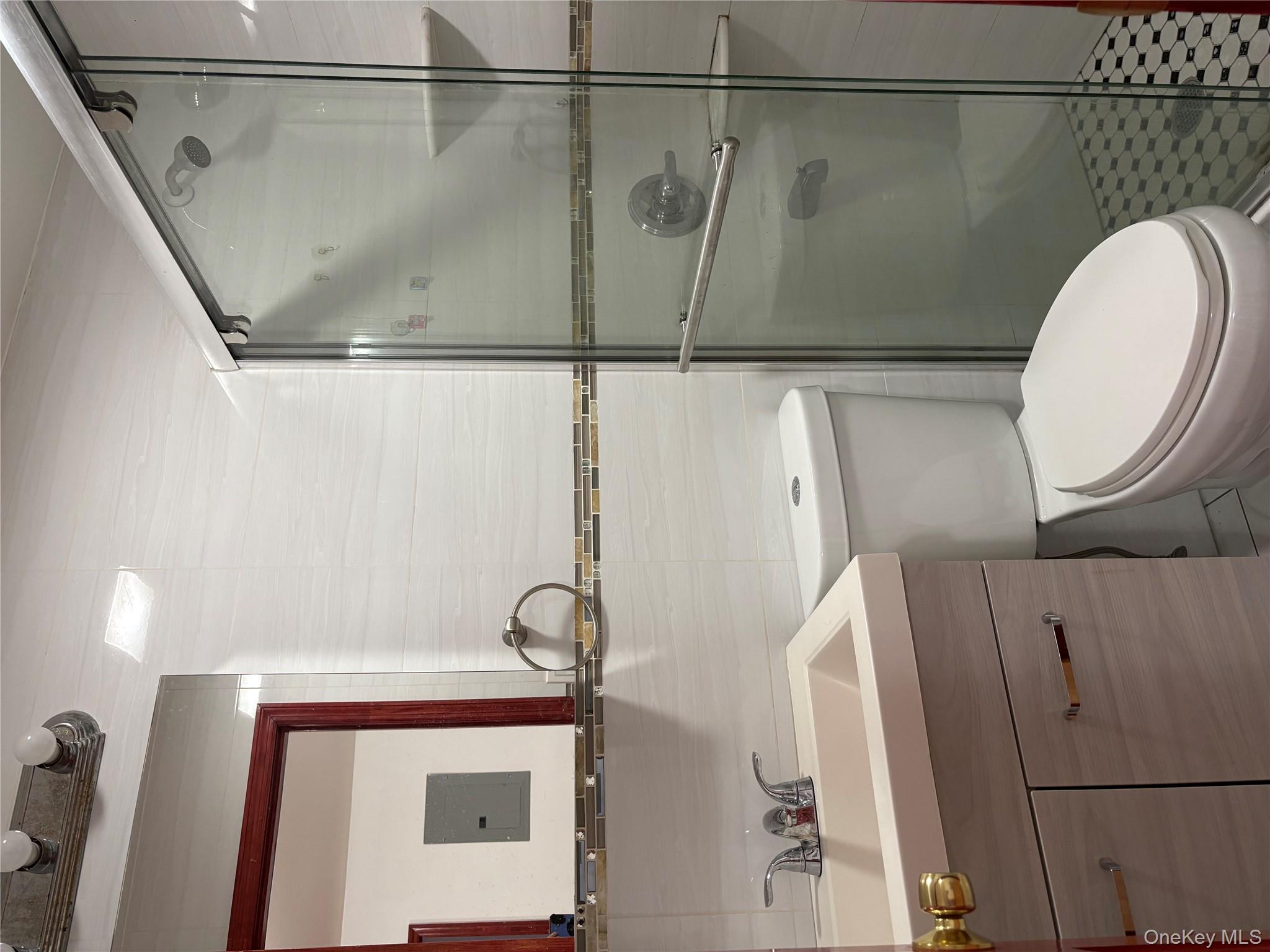 61-40 148th Street, Unit 2 Queens, NY 11367 - Photo 8 of 9 a bathroom with a sink a mirror a toilet and shower