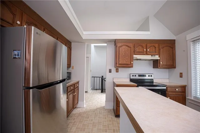 a kitchen with a refrigerator a stove top oven and a sink