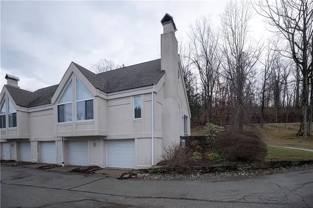 a view of a white house with a yard and large tree