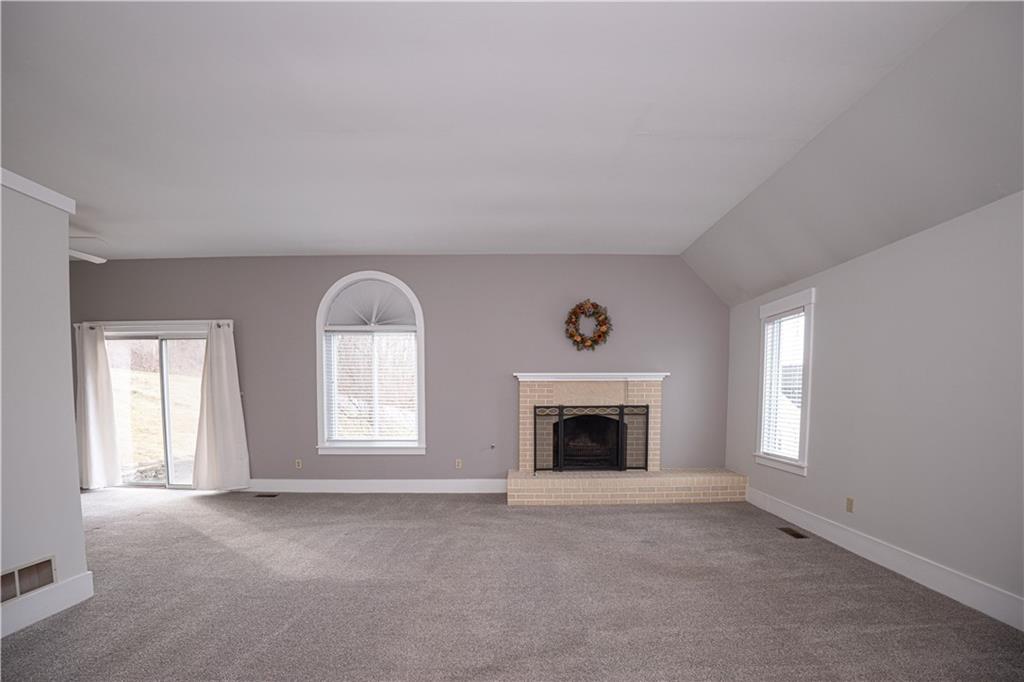 15 Ridgemead Fields Drive Plum, PA 15147 - Photo 4 of 32 an empty room with windows fireplace and mirror
