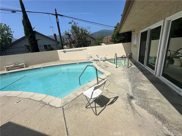 a view of a swimming pool with a patio and backyard