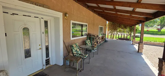 a view of a porch with chairs and backyard