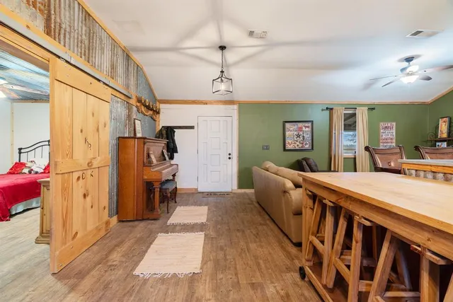 a room with stainless steel appliances kitchen island granite countertop a refrigerator a stove a sink and dishwasher a oven with wooden floor