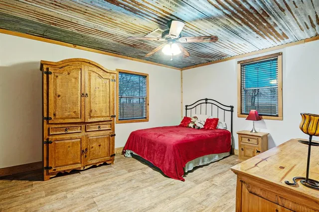 a bedroom with a bed next to a window