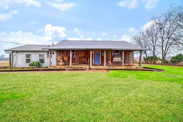 a front view of a house with garden and trees