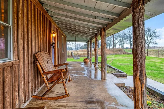 a view of a porch with chairs and backyard