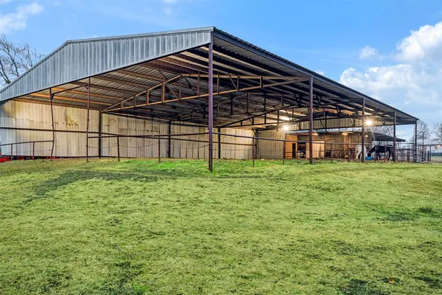 a view of a big house with a big yard and large trees