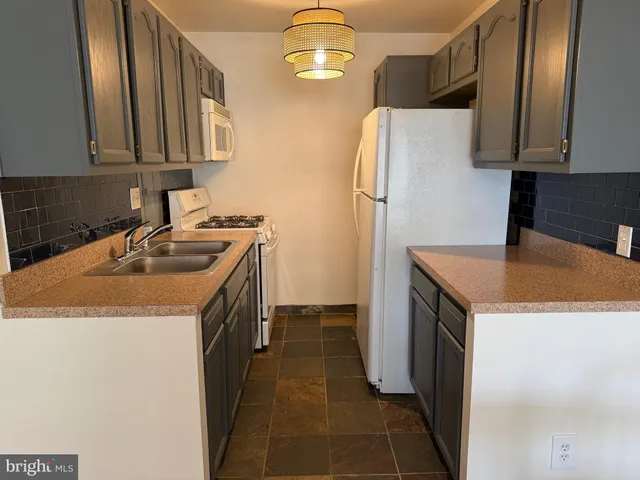 a kitchen with a sink a refrigerator and cabinets