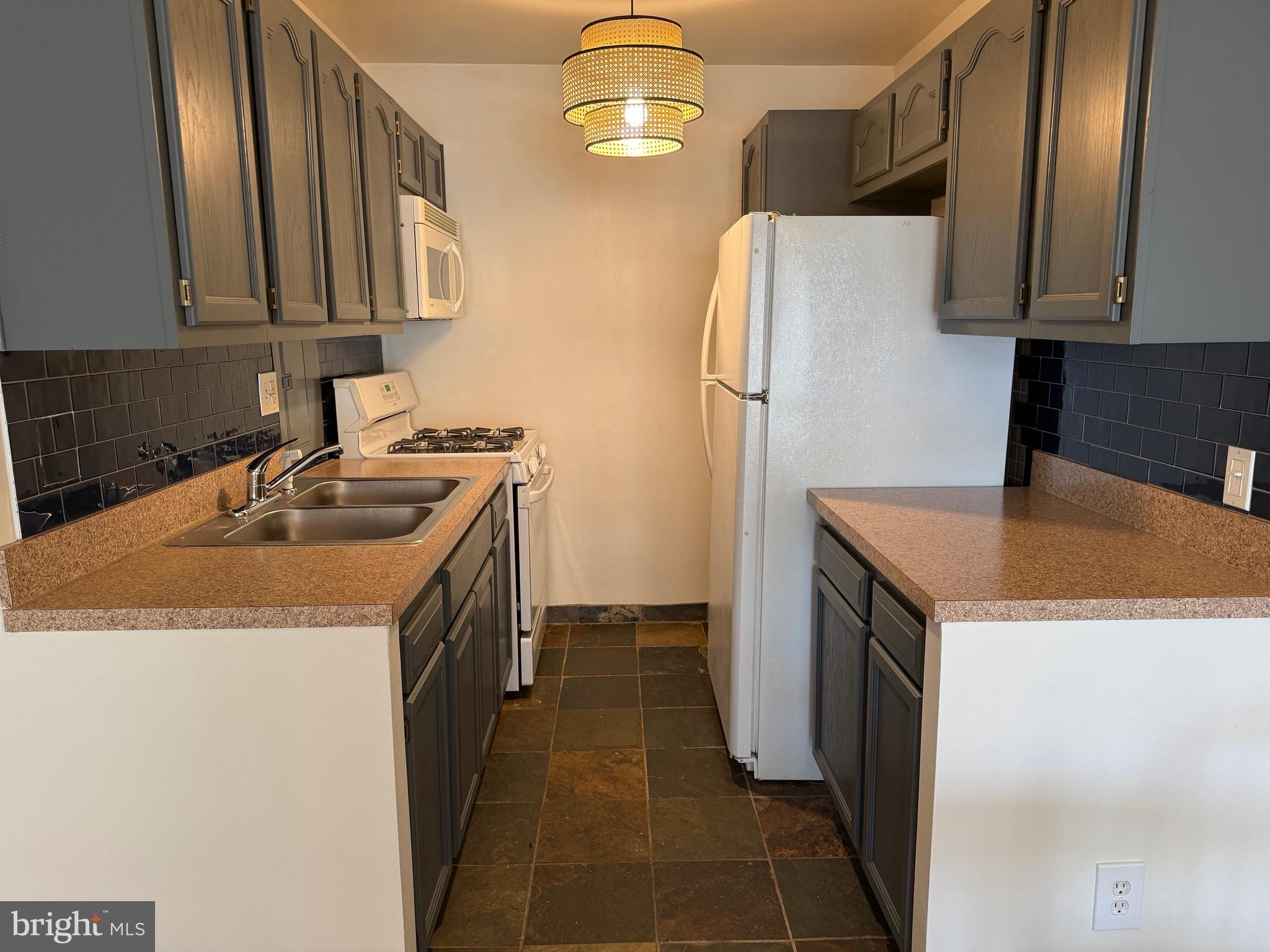 730 24th Street Northwest Washington, DC 20037 - Photo 5 of 6 a kitchen with a sink a refrigerator and cabinets