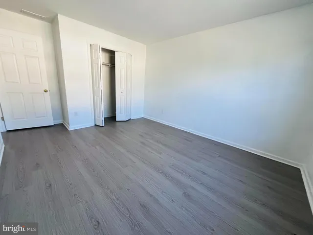 an empty room with wooden floor and closet