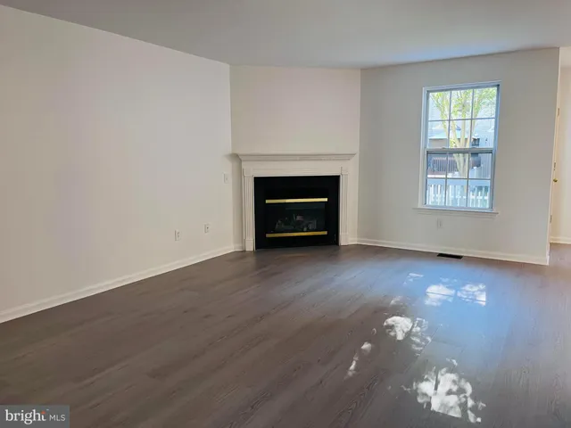an empty room with windows and fireplace