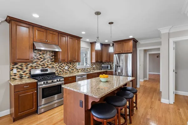 a kitchen with a stove a refrigerator and a wooden cabinets