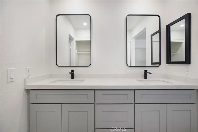 a bathroom with double vanity sinks and a mirror