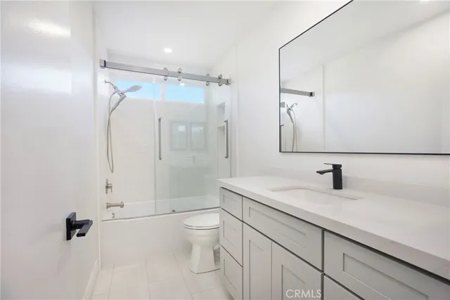 a bathroom with a granite countertop sink toilet a shower and a mirror