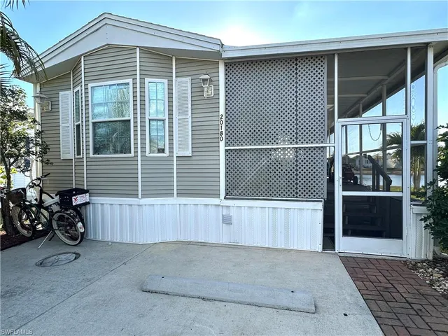 a view of a house with a wooden bench in front of door