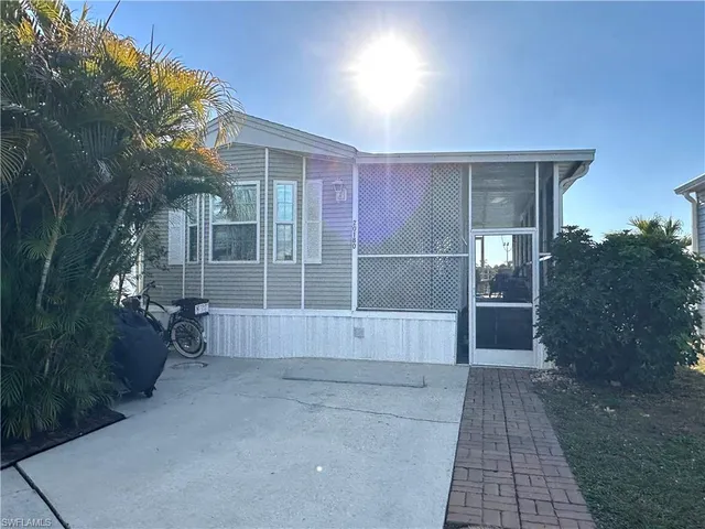 a view of a house with a yard and potted plants
