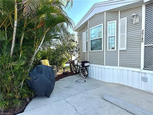 a view of a house with a yard and potted plants