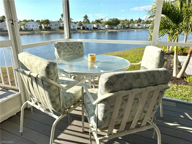 a open kitchen with stainless steel appliances granite countertop a dishwasher a kitchen island a dining table and chairs with wooden floor