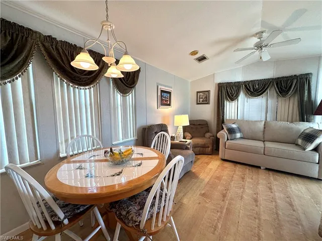 a kitchen with a stove a microwave and a table with wooden floor