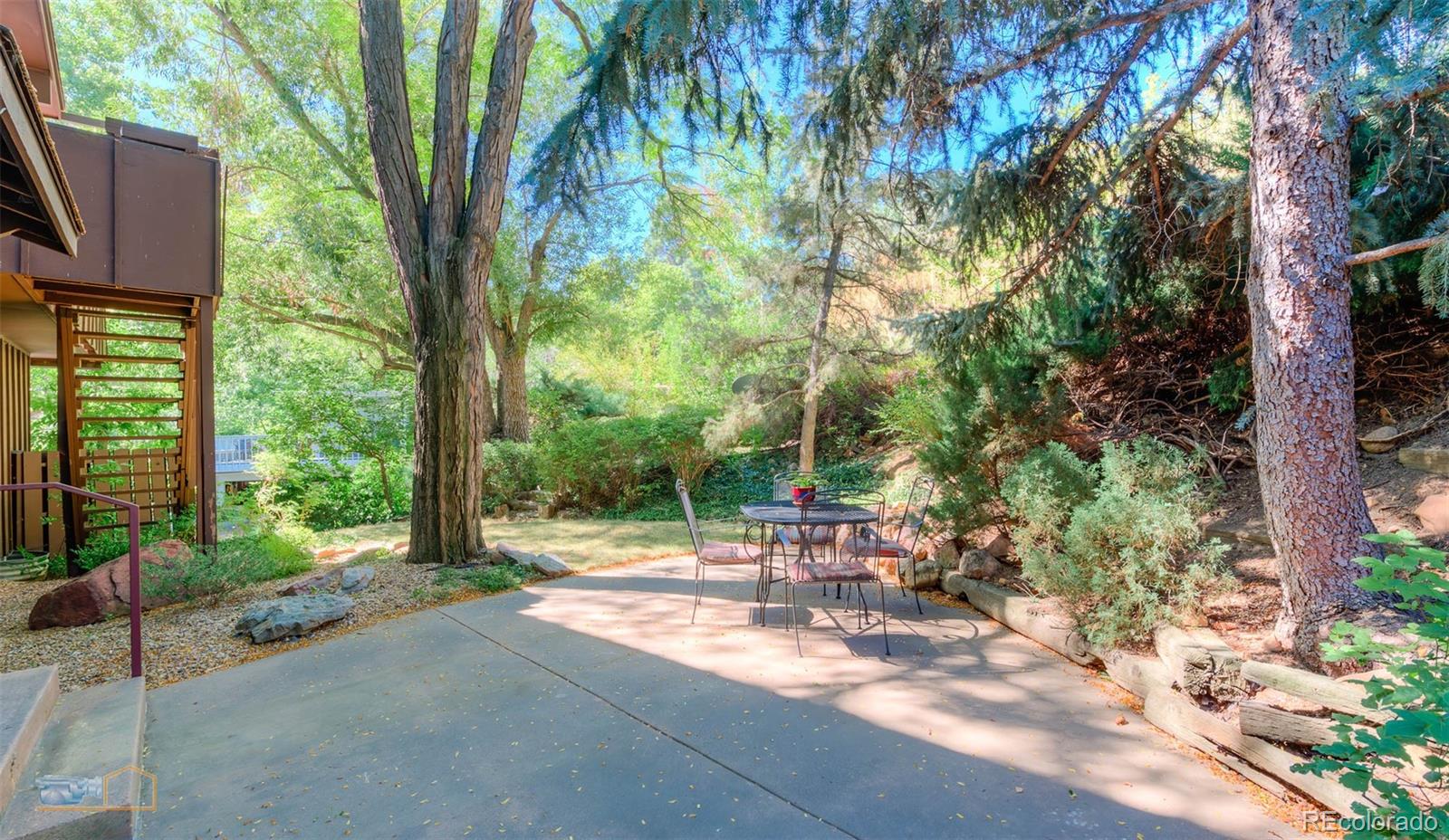 1425 Bellevue Drive Boulder, CO 80302 - Photo 34 of 40 a backyard of a house with table and chairs under an umbrella
