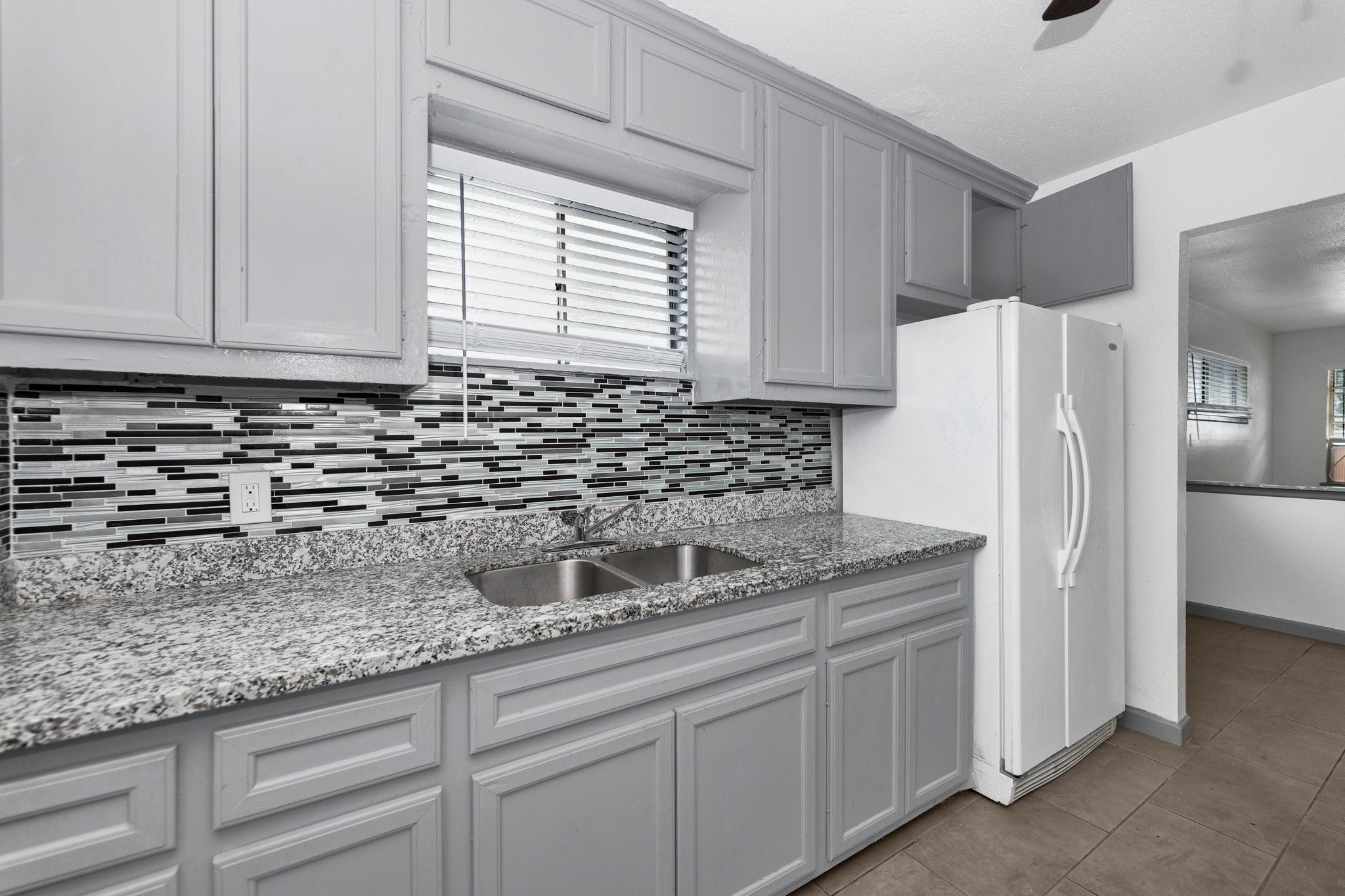 4203 Hirsch Road, Unit 14 Houston, TX 77026 - Photo 3 of 7 a kitchen with granite countertop a sink and a refrigerator