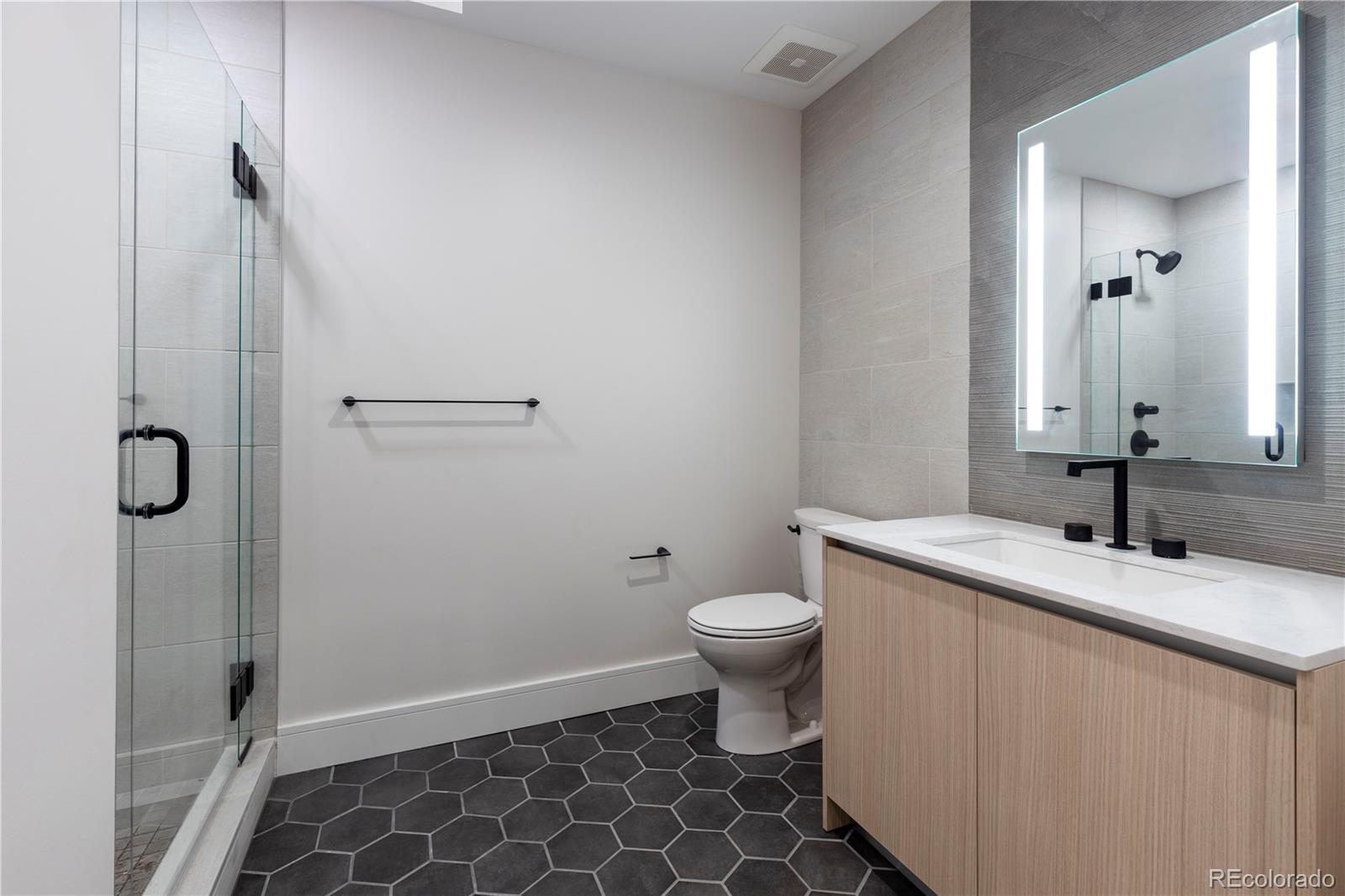 1901 Wazee Street, Unit 311 Denver, CO 80202 - Photo 10 of 17 a bathroom with a granite countertop sink a toilet and a mirror