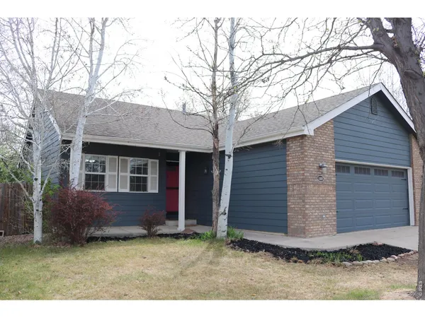 a view of house with backyard and trees