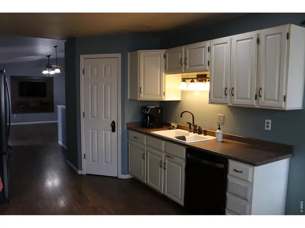 a kitchen with stainless steel appliances granite countertop a sink dishwasher a stove and a refrigerator with wooden cabinets