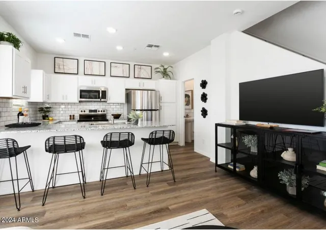 a kitchen with stainless steel appliances kitchen island granite countertop a refrigerator and microwave