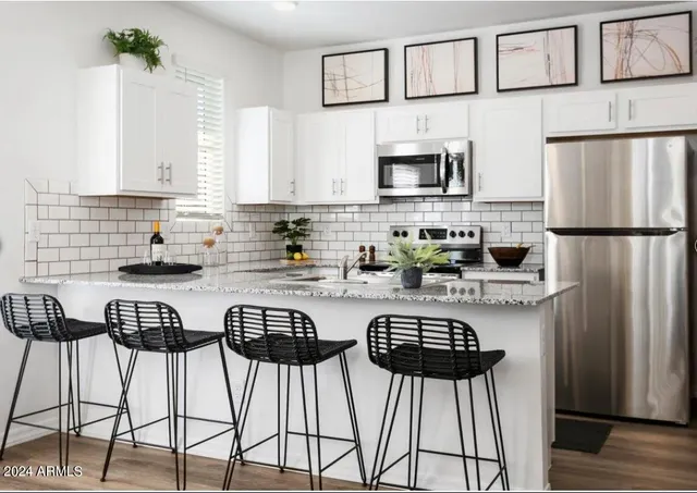 a kitchen with stainless steel appliances a refrigerator a stove a sink and a refrigerator