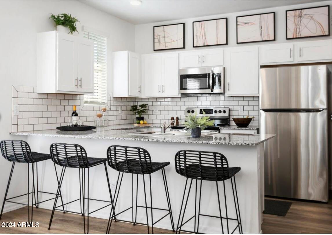 16520 North Greasewood Street, Unit 3 Surprise, AZ 85378 - Photo 4 of 16 a kitchen with stainless steel appliances a refrigerator a stove a sink and a refrigerator