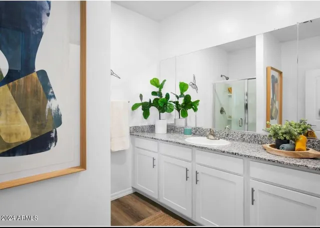 a bathroom with a granite countertop sink and a mirror